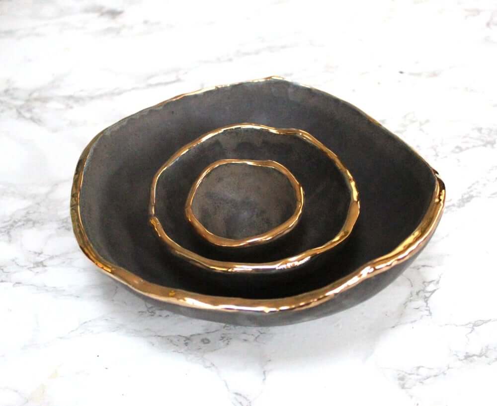 Black bowls with a gold rim. 