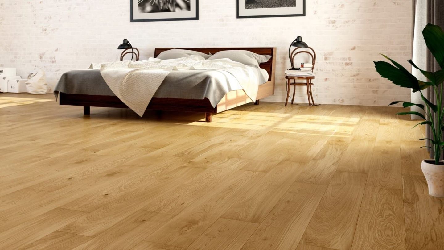 A white bedroom with a dark wood bed and medium wood floors.