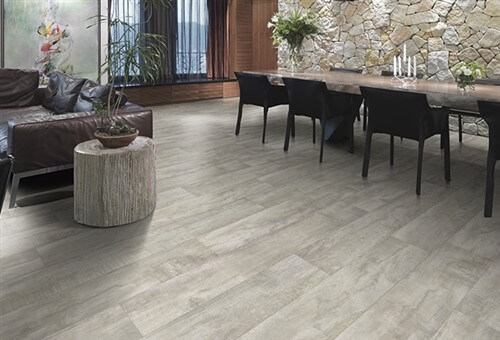 Dark wood dining table and chairs. Dark leather couch and grey vinyl floors.