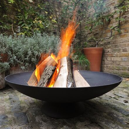 A black firepit with logs burning. 