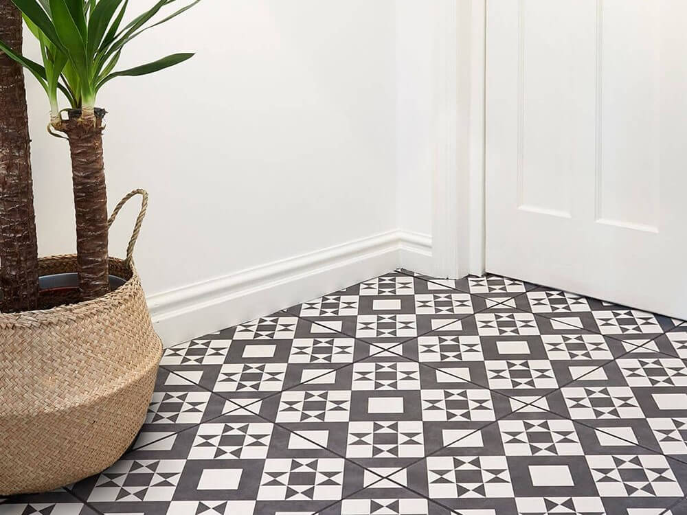 A room with white walls and black and white geometric floor tiles.