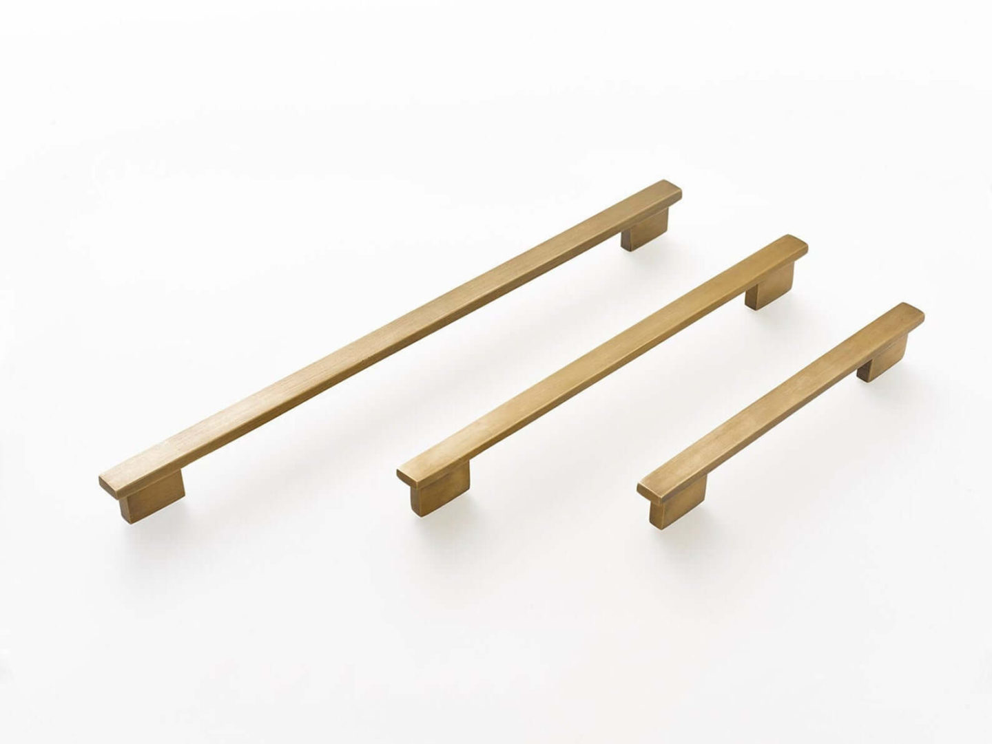 Three brass pull handles of varying length.