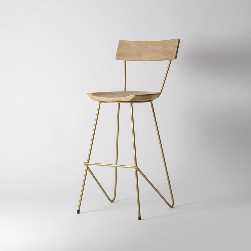 A light wooden stool with brass legs.