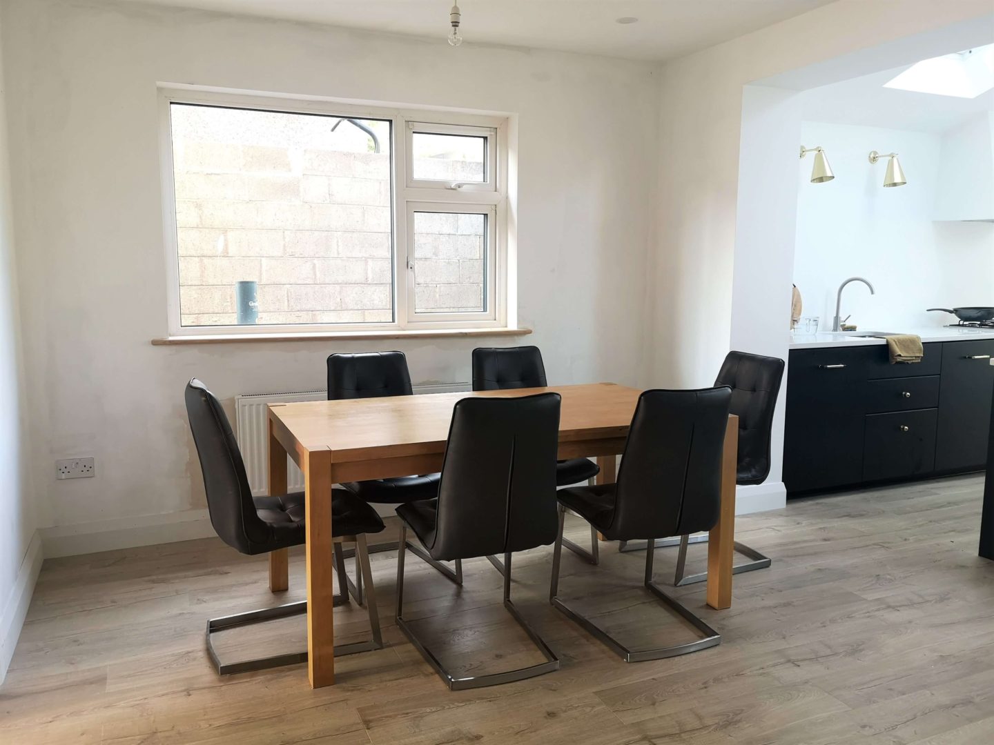 A dining table with six charcoal coloured dining chairs.