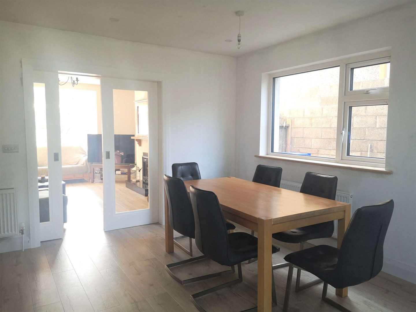 A view from a dining room to a living room through glass pocket doors.