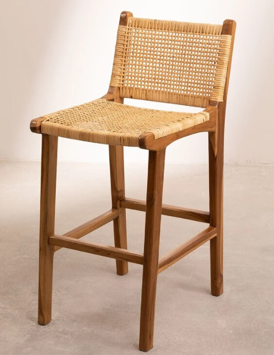 A wooden kitchen stool with rattan backing.