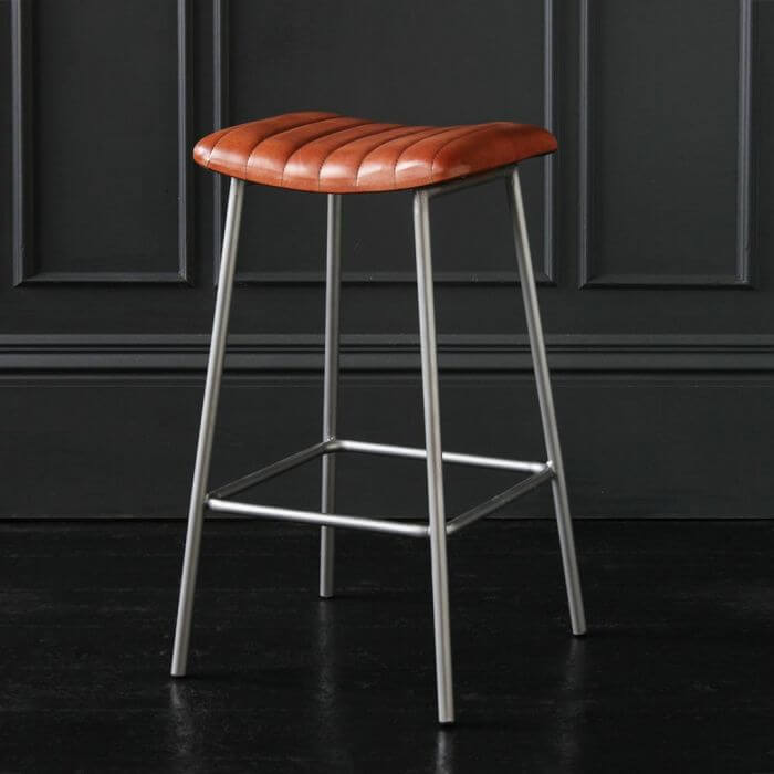 A backless leather stool with metal legs.