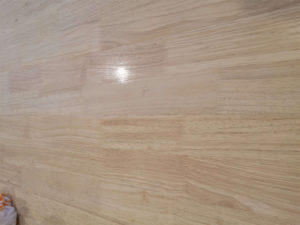 A table top half covered in osmo oil stain with a white tint.