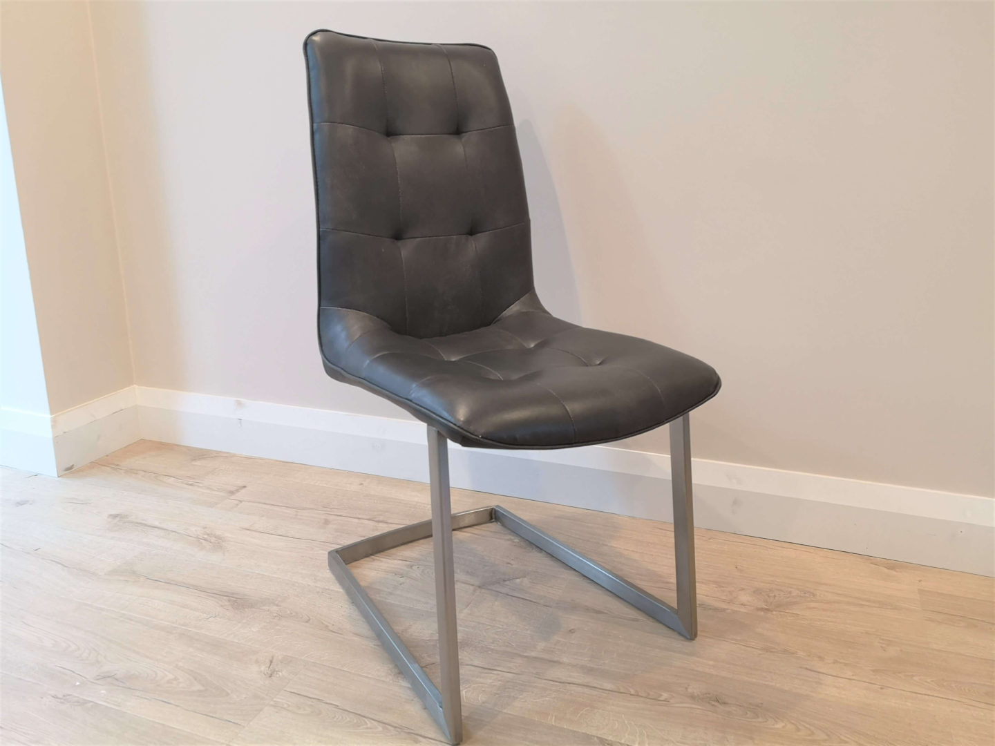 A grey, faux leather dining chair.