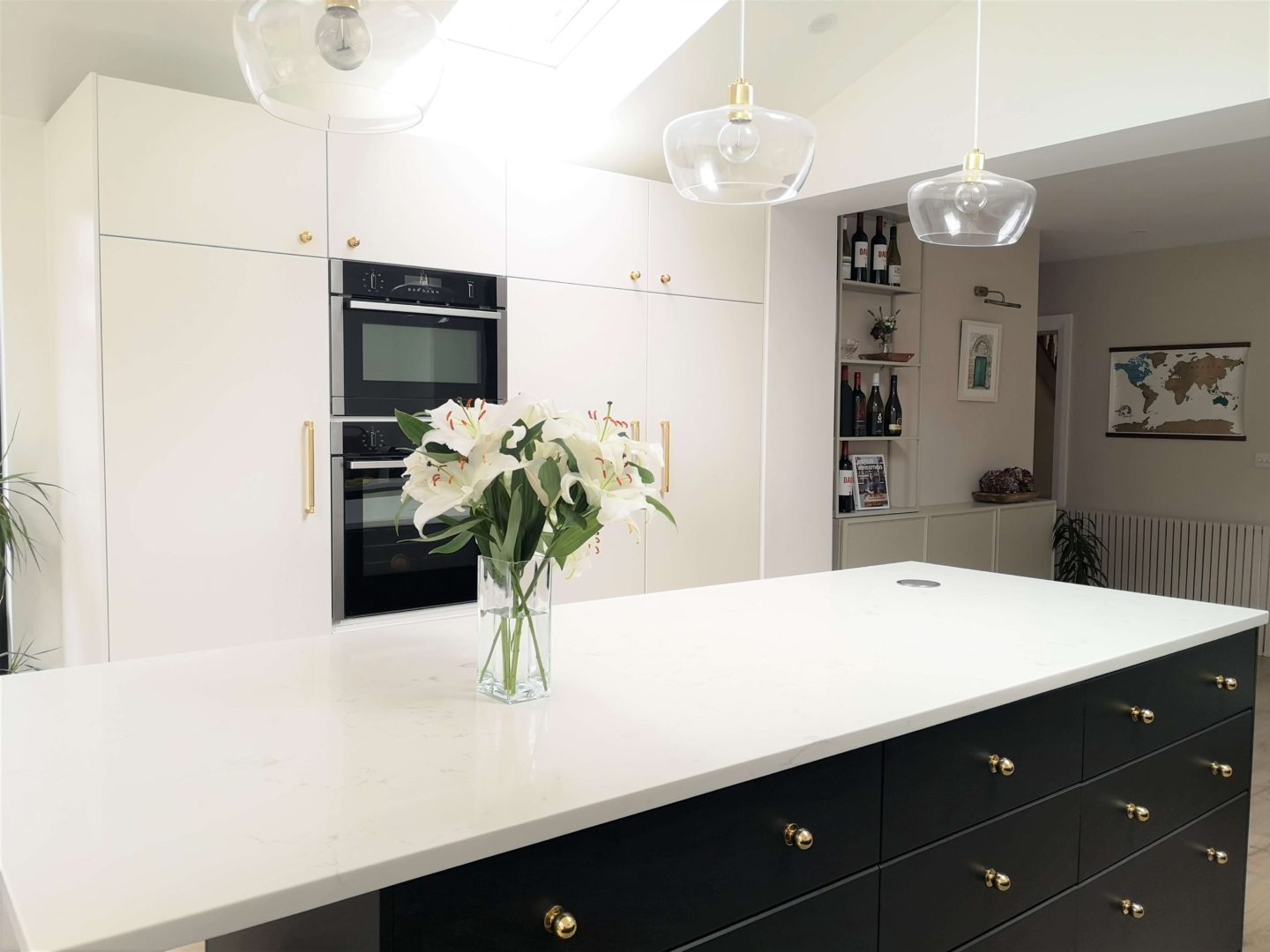 A kitchen with black and with cabinets with a white, marble quartz countertop.