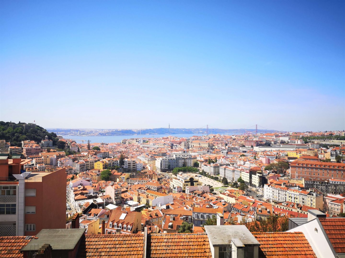 A photo from a high viewpoint above Lisbon, showing all the red roofs below. 