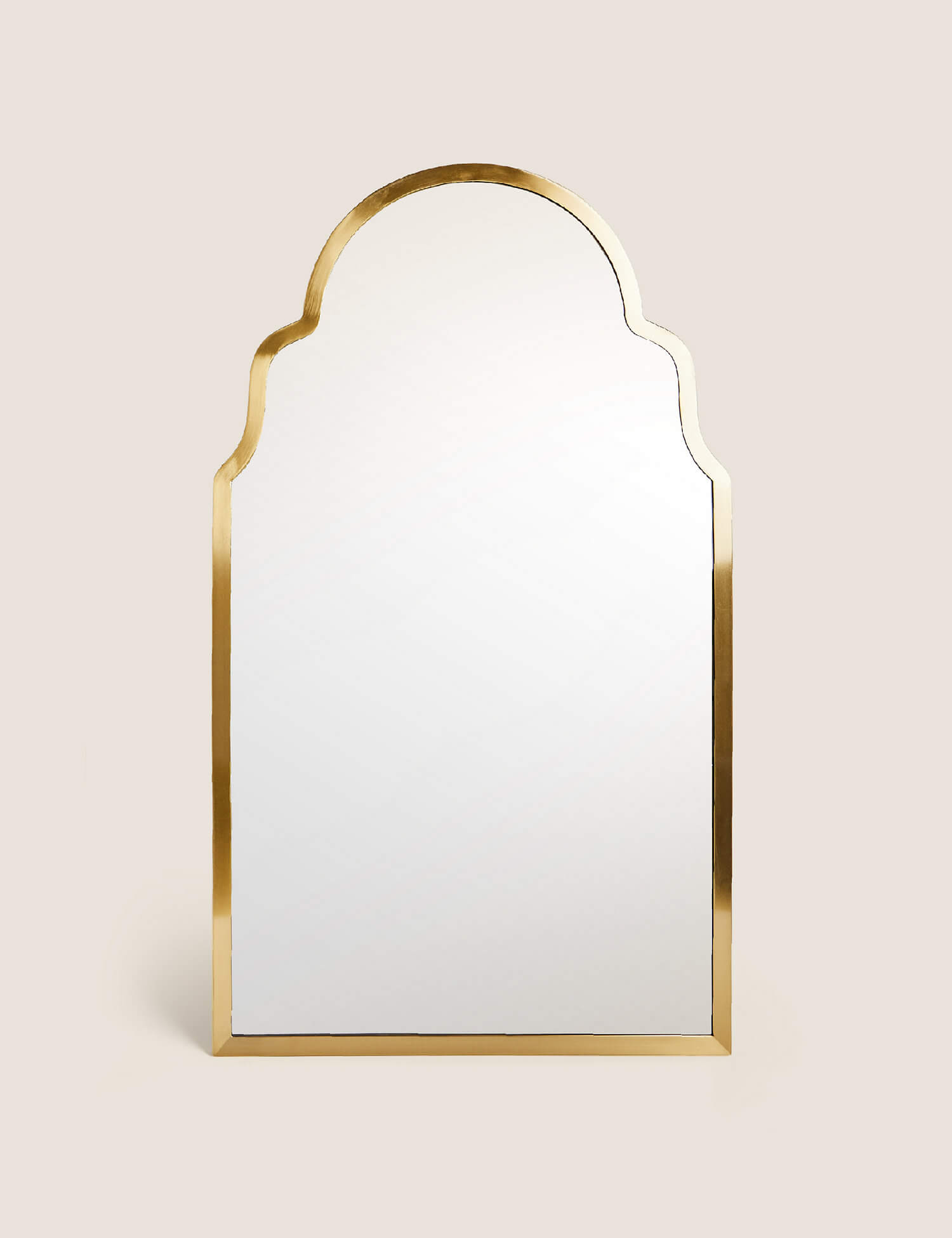 A brass mirror with Moroccan curves on top. 