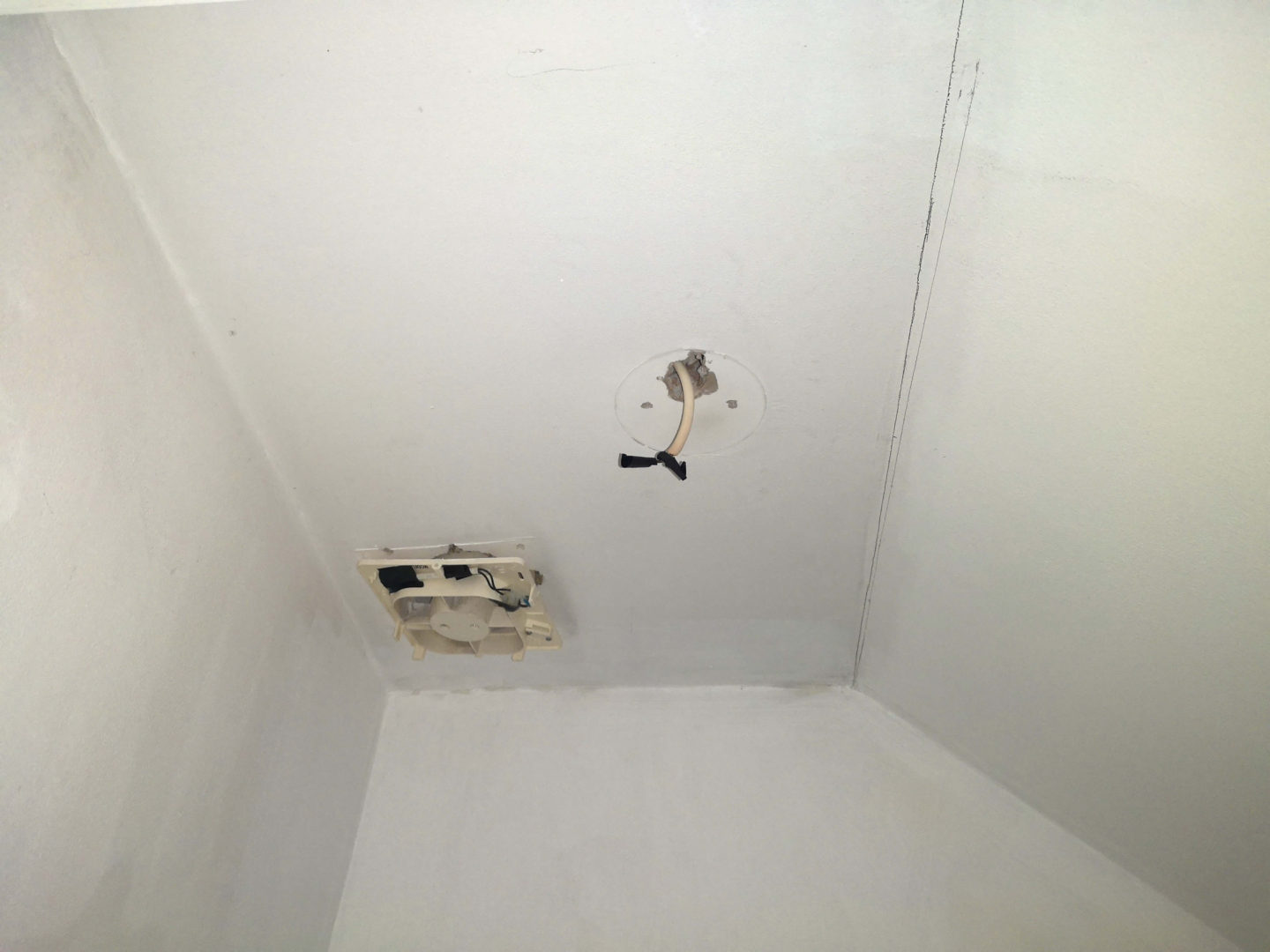 A small area of a ceiling with a light plate and vent removed. There is also a line drawn at the slope, where it is planned shiplap boards will meet. 