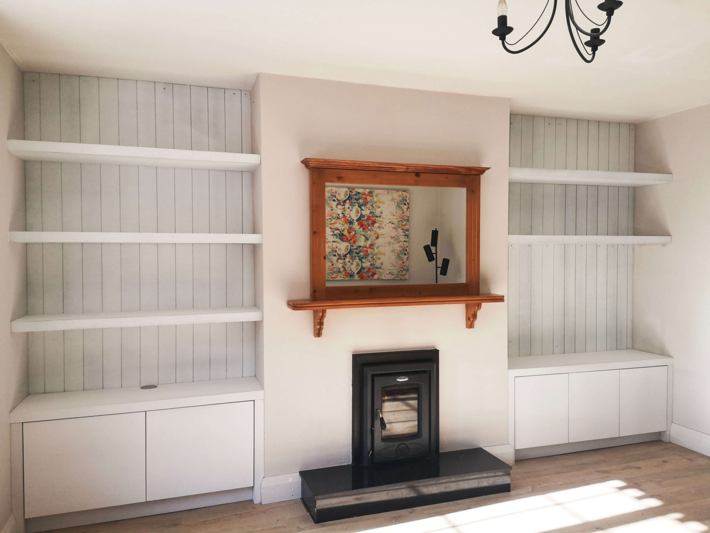 Living room built-ins on either side of the fireplace, primed. 