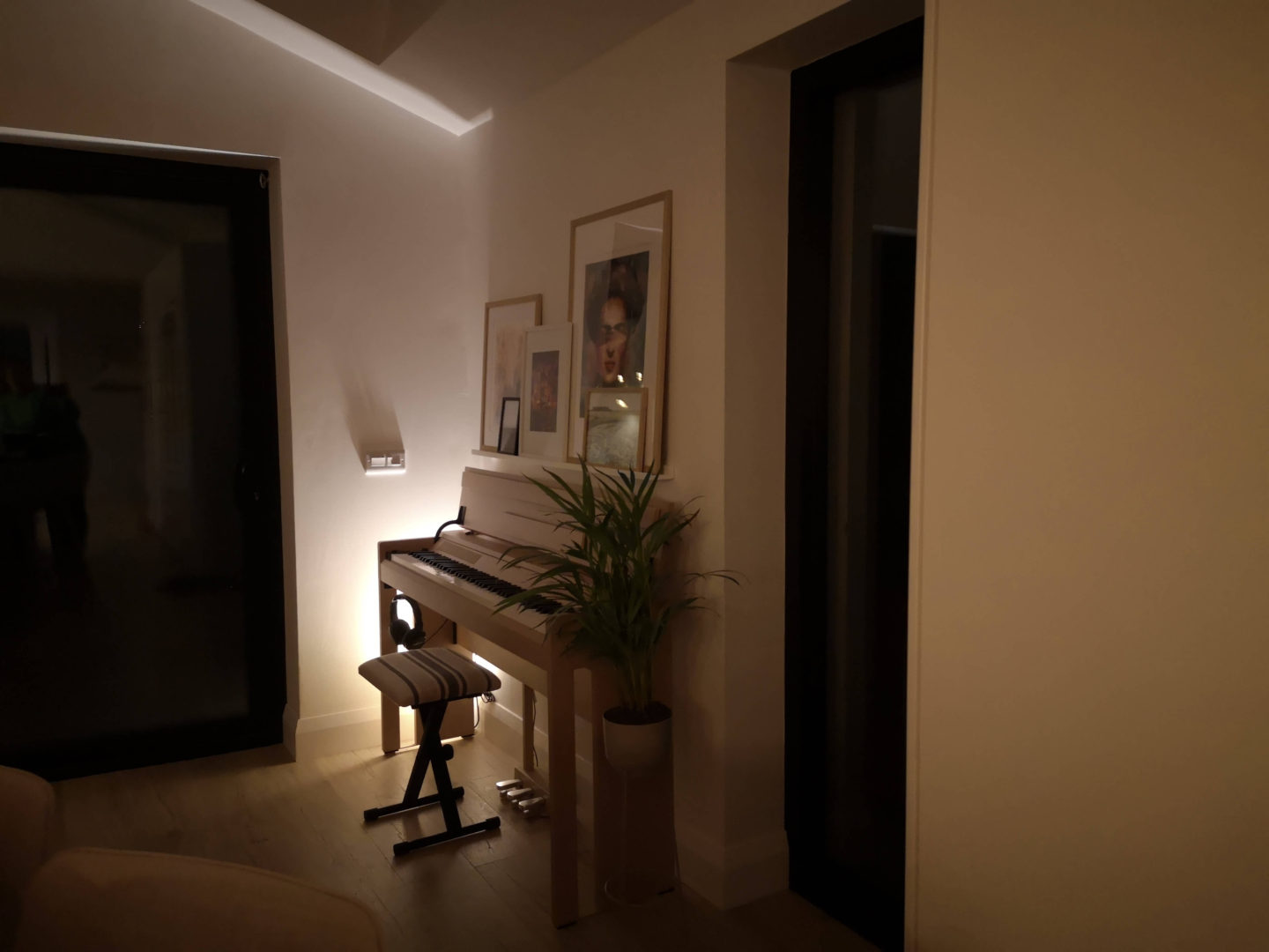 The piano corner at night with the uplighter behind it.