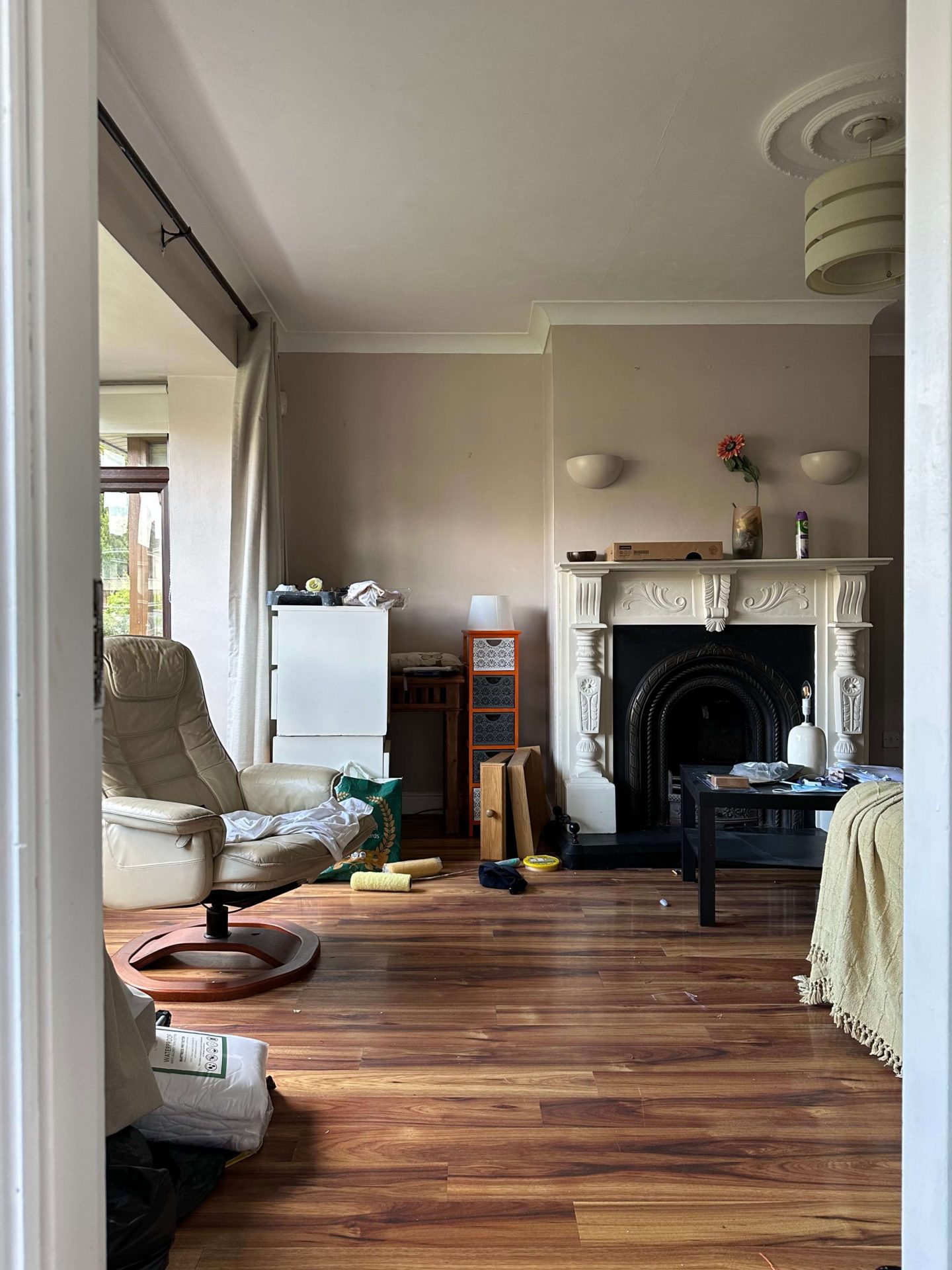 A before picture of a living room with dark taupe walls.