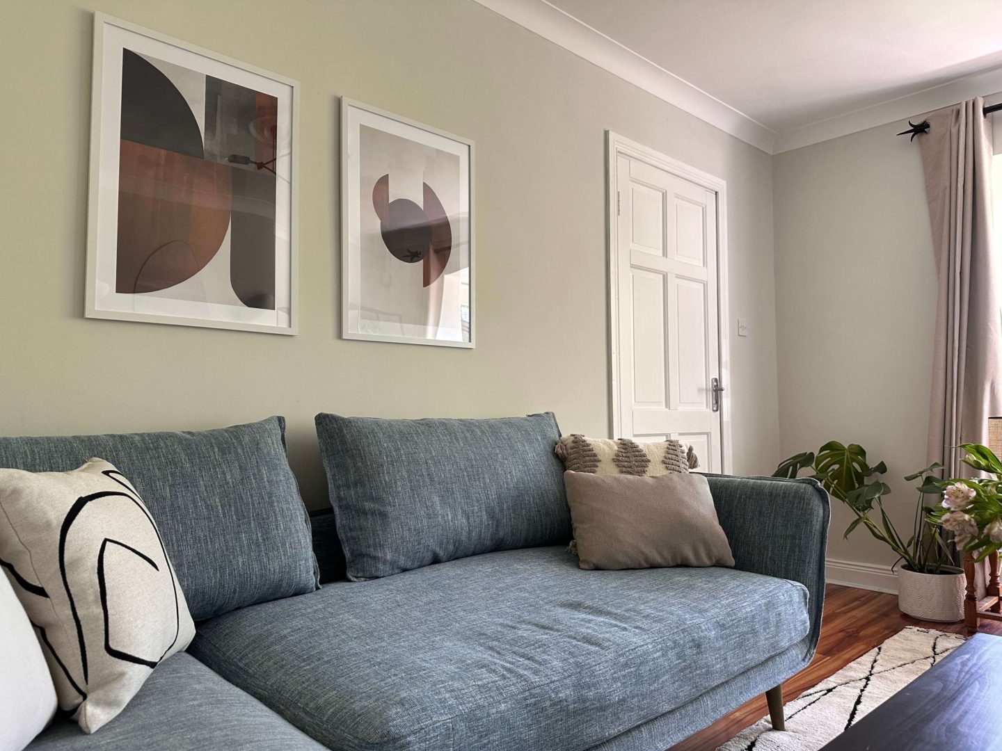 A living room with light green walls and a blue couch.