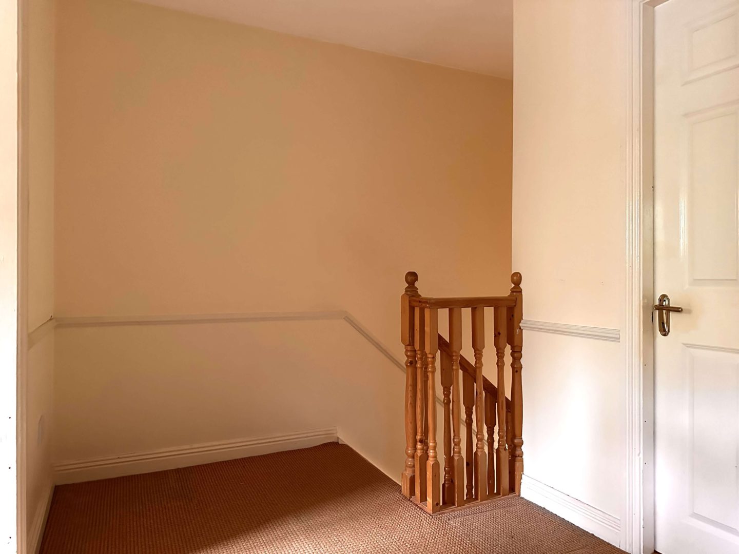 An old hallway with cream walls and a dado rail.