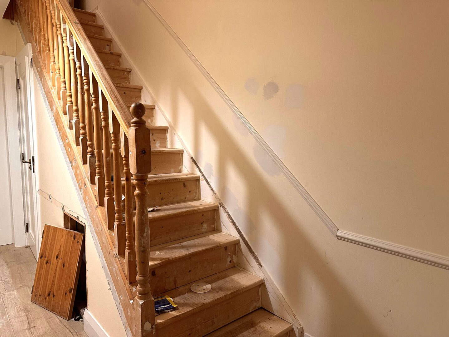 A hallway and stairs in the middle of sanding prep.