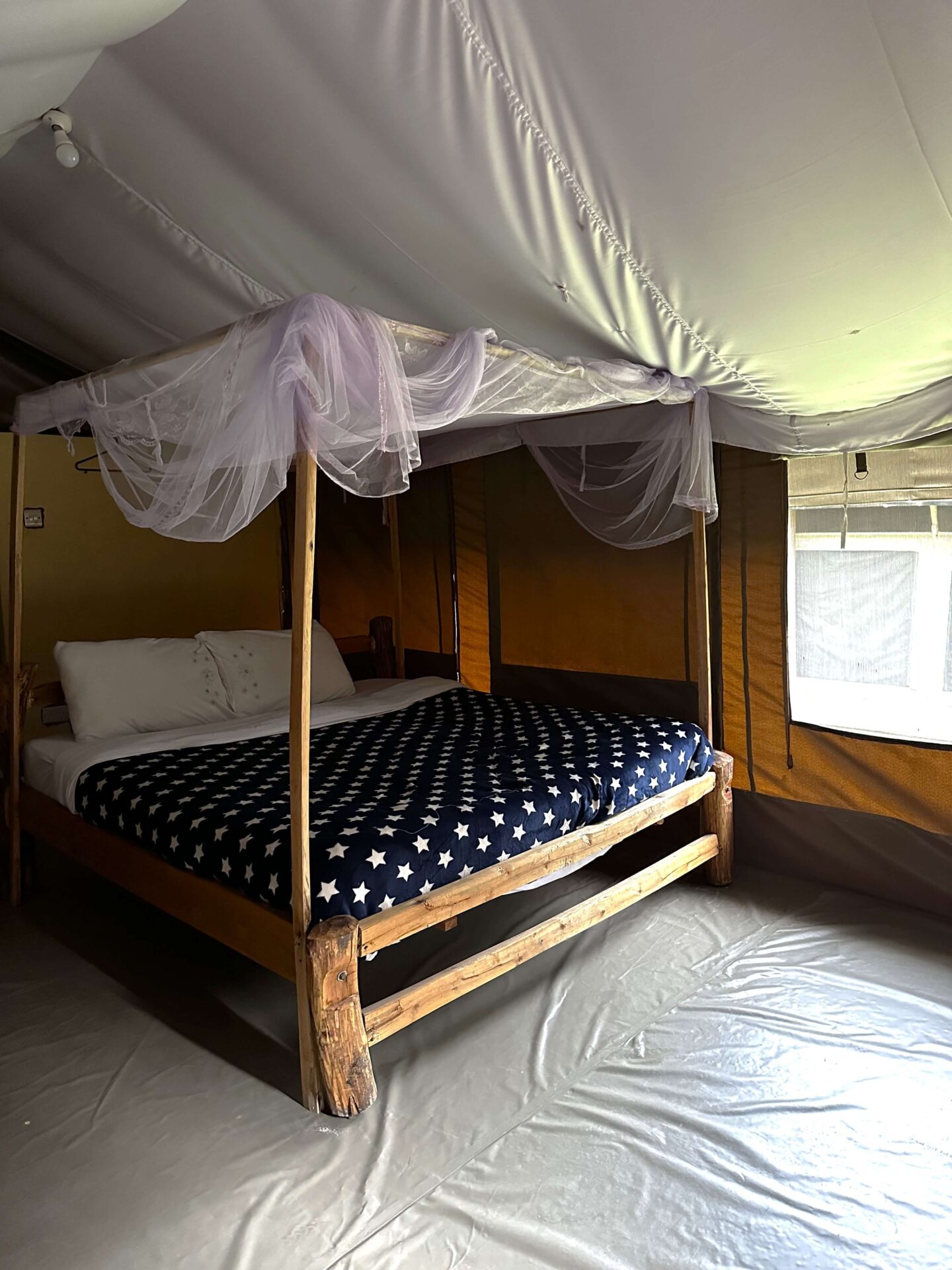 A four poster bed in a large tent.